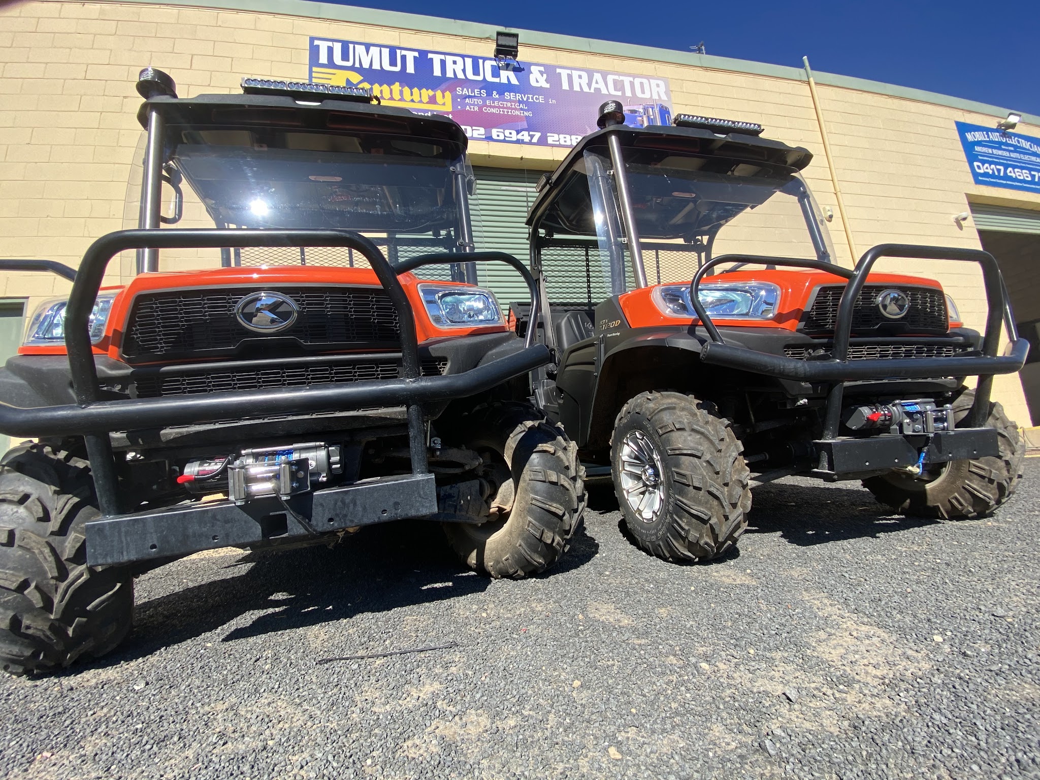 Two Kubota side by sides fitted with bullbars, winches and light bars outside the workshop